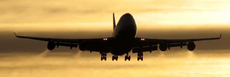 An Airplane flying off with a sunset